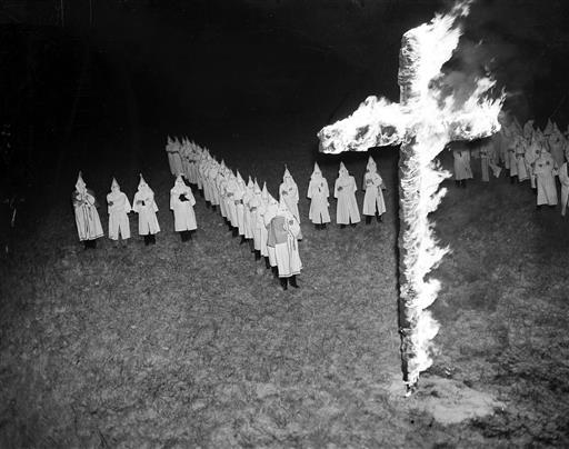 Membros da Ku Klux Klan queimando uma cruz