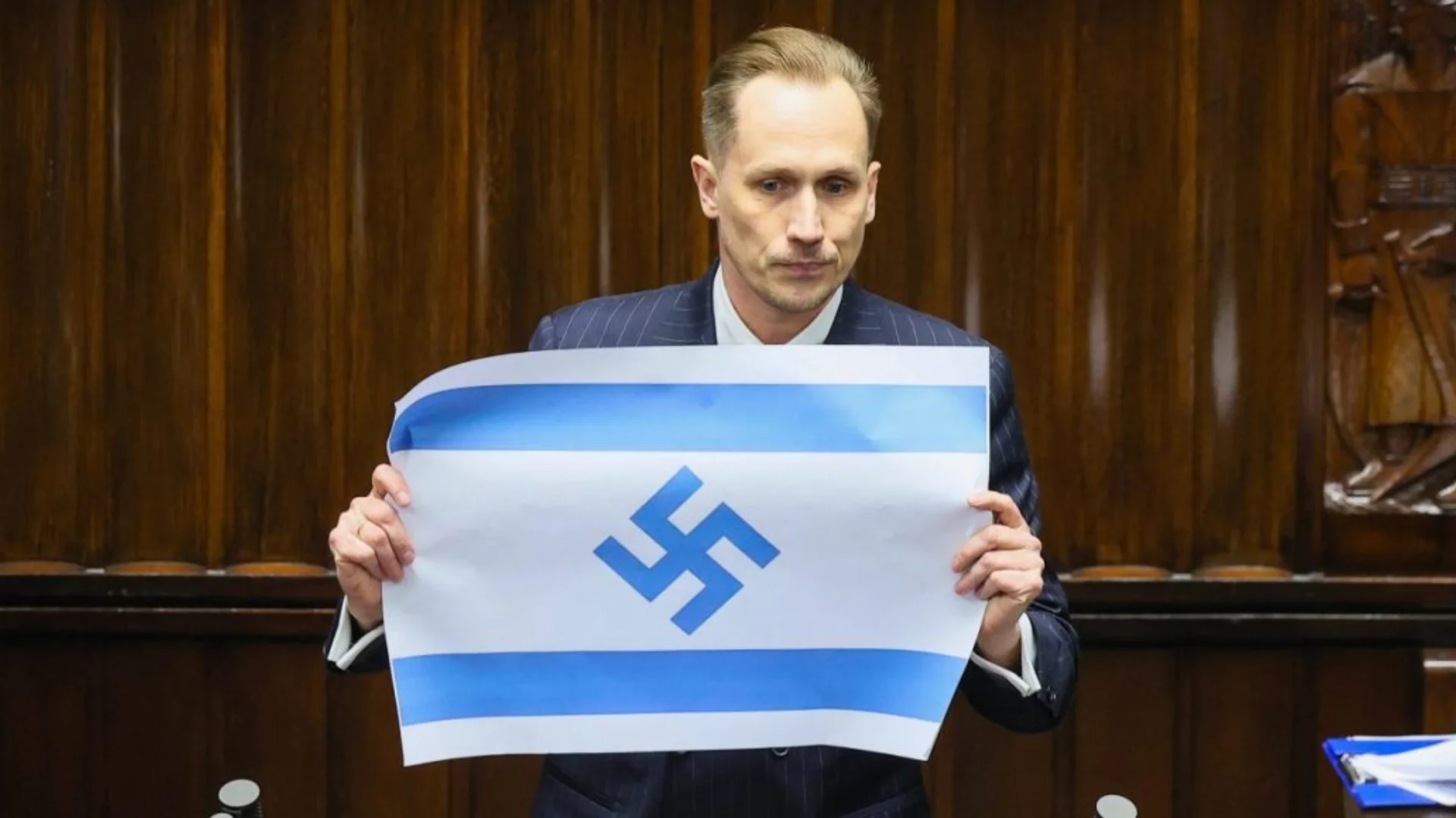 No dia 14 de abril, enquanto judeus ao redor do mundo recordavam as vítimas do Holocausto, o parlamento da Polônia foi palco de um episódio que gerou repercussão internacional. Durante uma sessão no Sejm, o deputado Konrad Berkowicz exibiu uma bandeira de Israel alterada com uma suástica no lugar da Estrela de Davi enquanto acusava o país de cometer genocídio. “Israel está cometendo genocídio diante de nossos olhos com particular crueldade; Israel é o novo Terceiro Reich”, afirmou da tribuna.