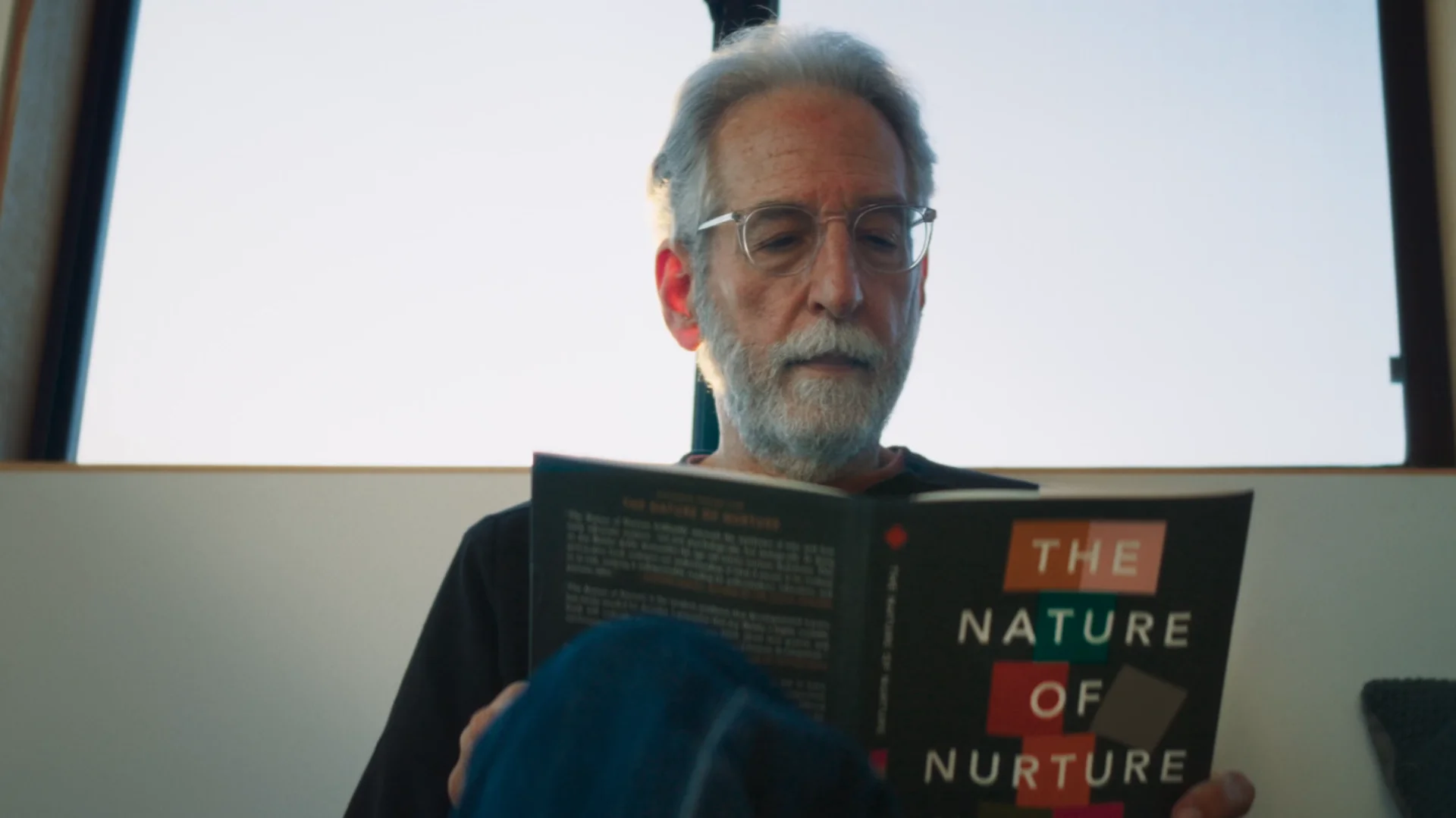Jay Belsky lendo o livro “The Nature of Nurture” durante gravação do documentário Pedagogia do Abandono
